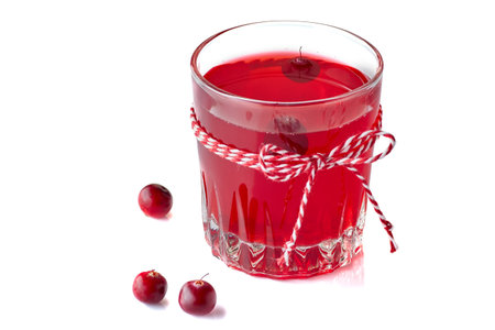 Glass of cranberry fruit drink isolated on white background and decorated with white-red ropeの写真素材