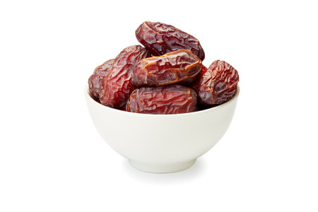 Bowl of dried date fruits on whiteの写真素材