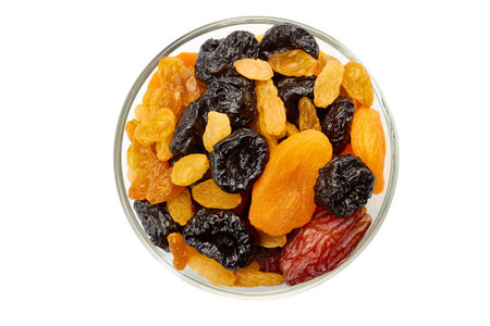 Glass bowl of dried fruits mix on whiteの写真素材