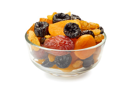 Glass bowl of dried fruits mix on whiteの写真素材