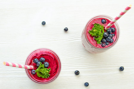 Two jars of blueberry smoothie on white wooden tableの写真素材