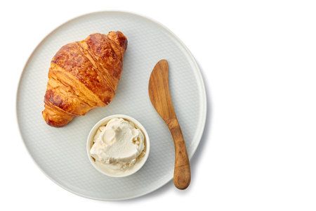 Plate with fresh croissant and cream cheese on whiteの写真素材