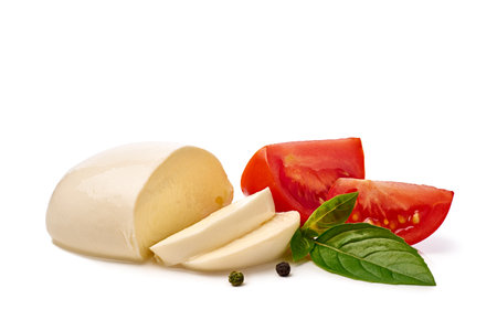 Fresh sliced mozzarella cheese with tomato and basil on whiteの写真素材