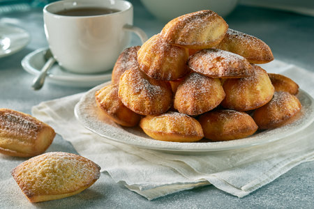 Madeleine cookies with tea on gray stone table