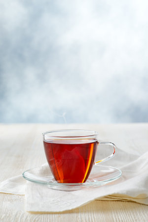 Glass cup of black tea on white wooden tableの写真素材