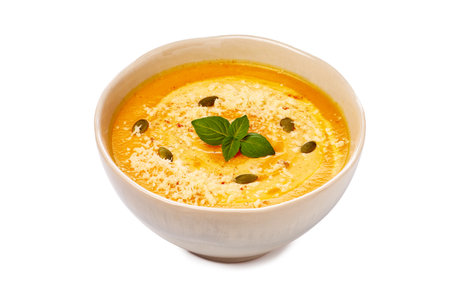 Indulge in a Deliciously Creamy Soup that features a Garnish of Fresh Basil and an Array of Spicesの写真素材
