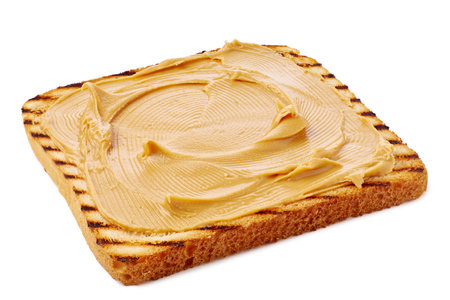 Enjoy a Creamy Peanut Butter Spread on a Deliciously Toasted Slice of Fresh Breadの写真素材