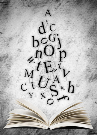 Open book with falling letters over grunge abstract backgroundの写真素材