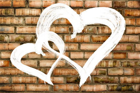 Two hearts love symbol painted on old brick wall backgroundの写真素材