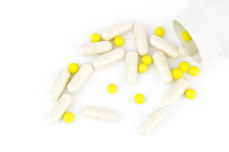 medicine capsules scattered on a white background with room for textの写真素材