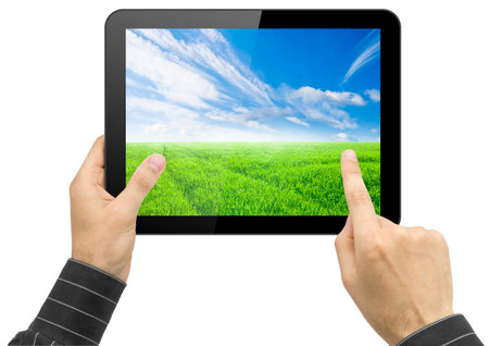 Black tablet pc with nature wallpaper in hands on white background. Portable computerの写真素材