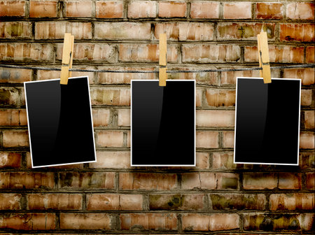 Photo frames with pins on rope over old aged brick wall backgroundの写真素材