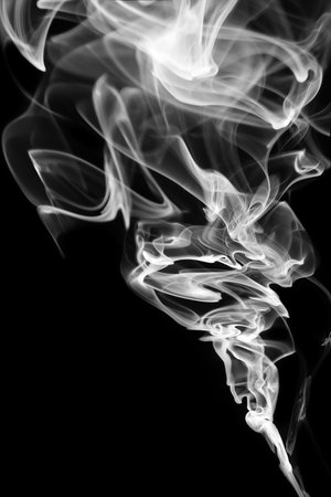 Abstract white smoke swirls over black backgroundの写真素材