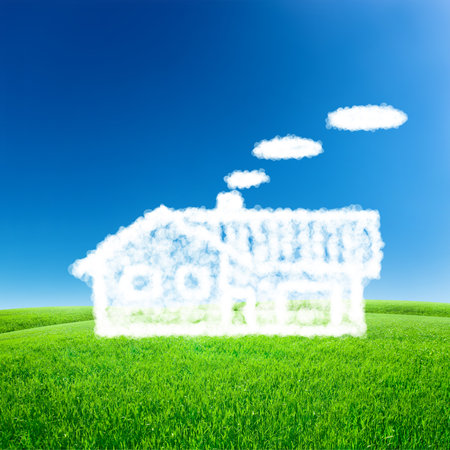 House from white clouds over blue sky with green fieldの写真素材
