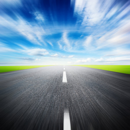 asphalted highway over blue sky with white clouds の写真素材
