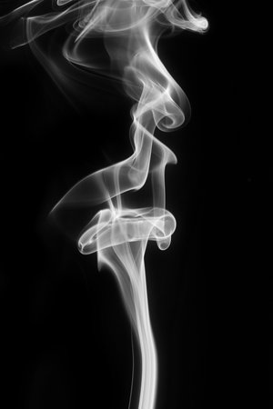Abstract white smoke swirls over black backgroundの写真素材