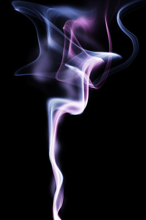 Abstract color smoke swirls over black backgroundの写真素材