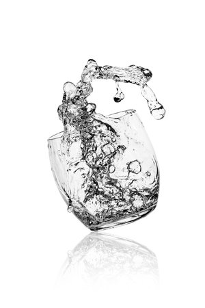 glass with water splash over white backgroundの写真素材