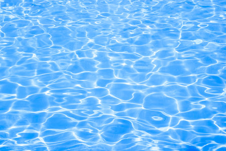 Blue swimming pool rippled water with sunny reflections backgroundの写真素材