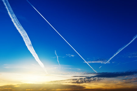 Blue sky with white stripes of plane backgroundの写真素材