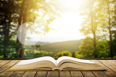 Book on wood planks over beauty mountains landscape backgroundの写真素材