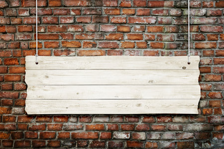 Wooden sign with ropes isolated over brick backgroundの写真素材