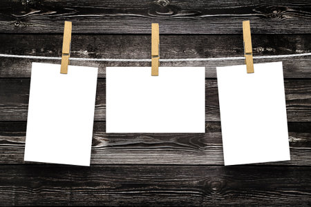 Photo frames with pins on rope over old aged wood wall background