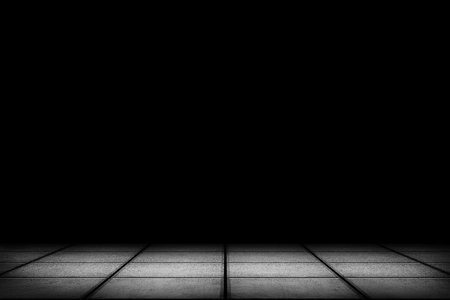 Dark room with tiled floor and black backgroundの写真素材