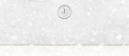 Old white clock on concrete wall in light vintage room background with snow fallingの写真素材