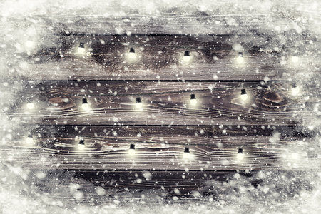 The brown wood texture with garland and snow flakes over it. Christmas holiday backgroundの写真素材