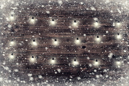 The brown wood texture with garland and snow flakes over it. Christmas holiday backgroundの写真素材