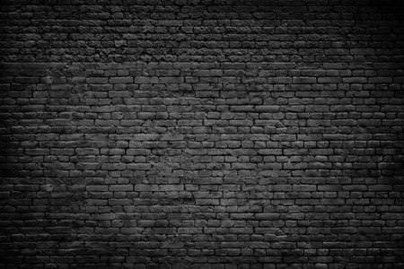 Old dark brick stones wall backgroundの写真素材