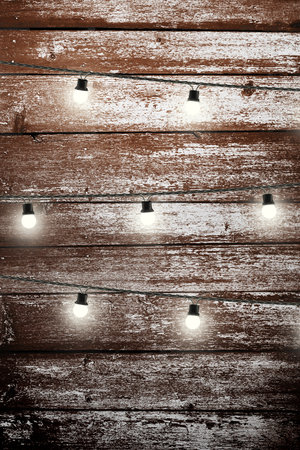 Garland lamps over wooden board fence. Decoration backgroundの写真素材