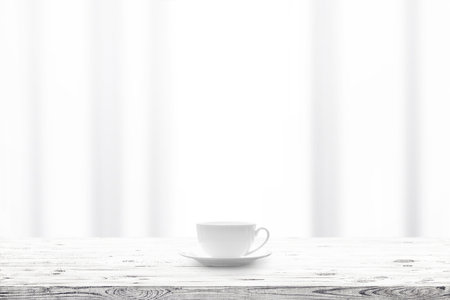 Cup with hot drink on wooden table and window curtains on a backgroundの写真素材