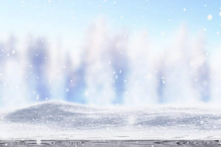 Winter snow covered forest behind wooden tableの写真素材