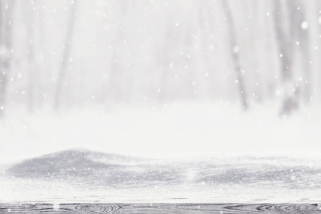 Winter snow covered forest behind wooden tableの写真素材