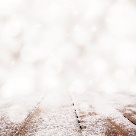 Christmas golden bokeh behind wooden table with snow backgroundの写真素材