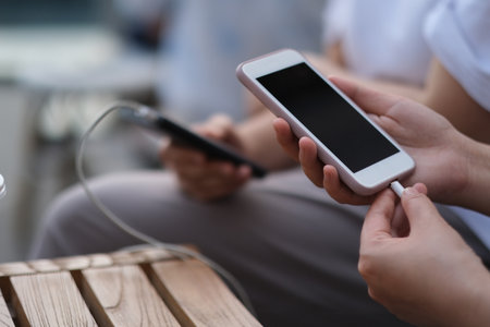 close up hand sharing mobile power supply (Charge Pal) to charge phone