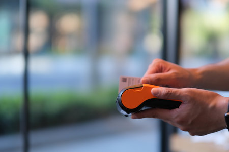 close up hands swiping the credit card on pos terminal. Bank card payment
