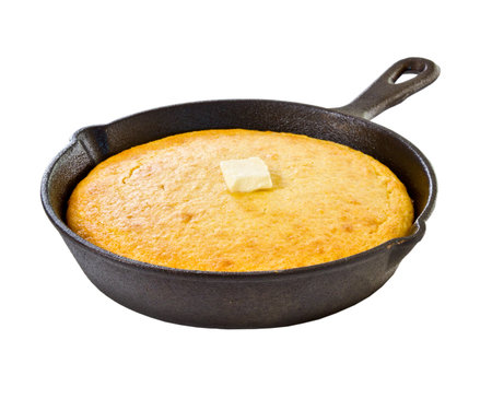 Corn bread in iron skillet isolated on white