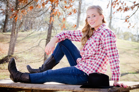 Outdoor portrait of beautiful blonde woman in western clothing の写真素材