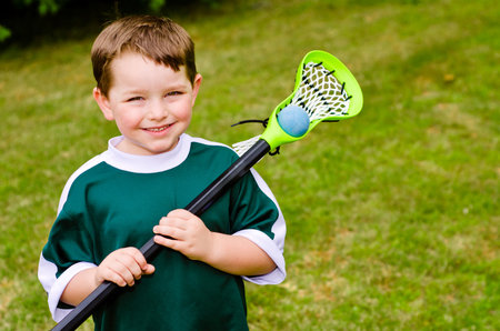 Happy young child lacrosse player with his stickの写真素材