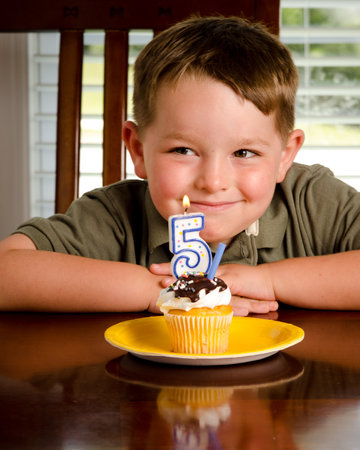 Young boy blowing out his birthday candleの写真素材