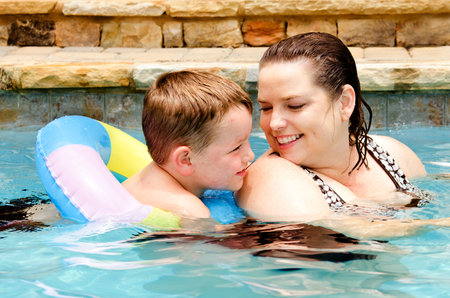 Mother and son swimming together while on vacationの写真素材