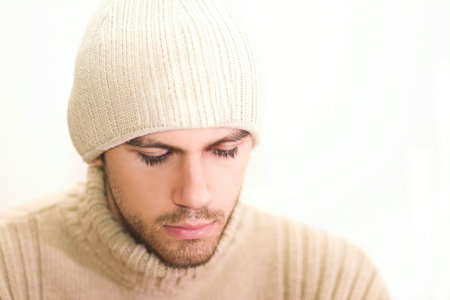 Man with hat looking down. Very shallow DOF with focus on eyes and lips.の写真素材