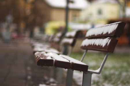 abandoned benches in park. winter scene with snow. very shallow depth of field (F / 1.8). space for textの写真素材