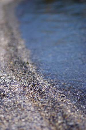 Calm blue sea and beach shells. Very shallow DOF achieved, with big copy space.の写真素材