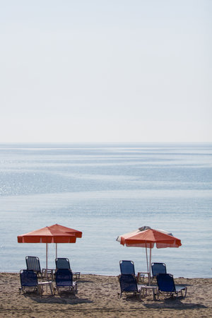 Vertical summer shot with chairs under umbrellasの写真素材