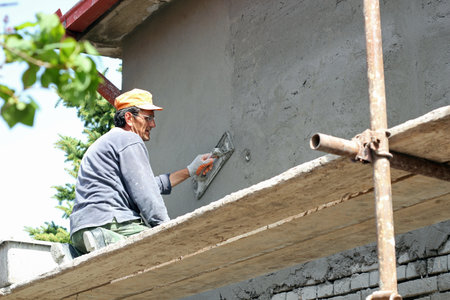 Mature contractor plasterer working outdoors   Selective focus の写真素材