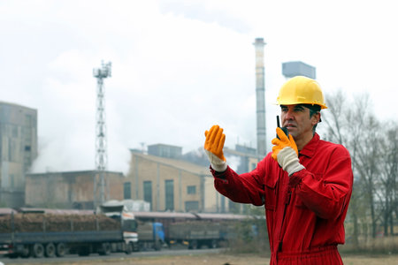 Industrial Worker Talking on Walkie-Talkie  Portrait of a worker using walkie-talkie in sugar refinery の写真素材